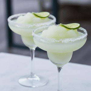 Vaso de granizado de margarita con bordes de sal y rodaja de lima, preparado con Mambo de Cecotec.