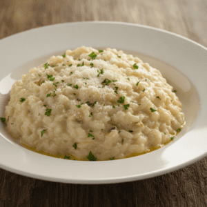 Imagen de risotto cremoso preparado en Mambo Cecotec, servido en un plato moderno con perejil fresco encima.
